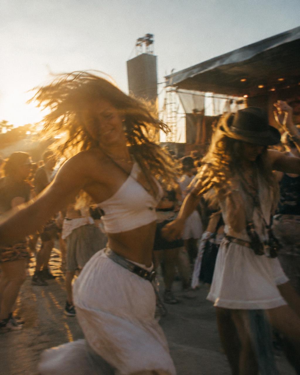 Pessoas dançando ao pôr do sol no festival
